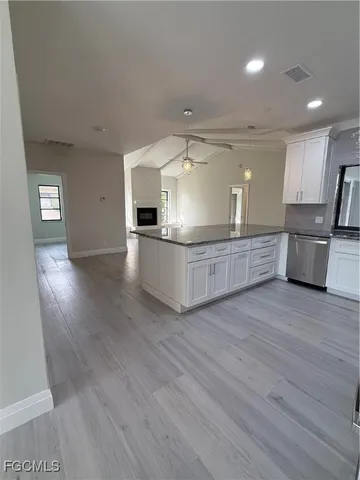 a large kitchen with a wooden floor and stainless steel appliances