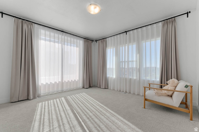 8307 Durham Street Sandy, UT 84070 - Photo 13 of 29 Expansive room featuring multiple windows, neutral tone carpeting, and a flush mount ceiling light fixture