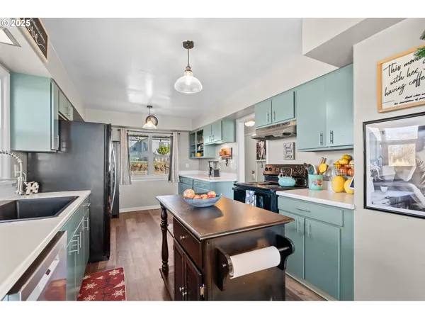 a kitchen with kitchen island a stove a sink a refrigerator and chairs