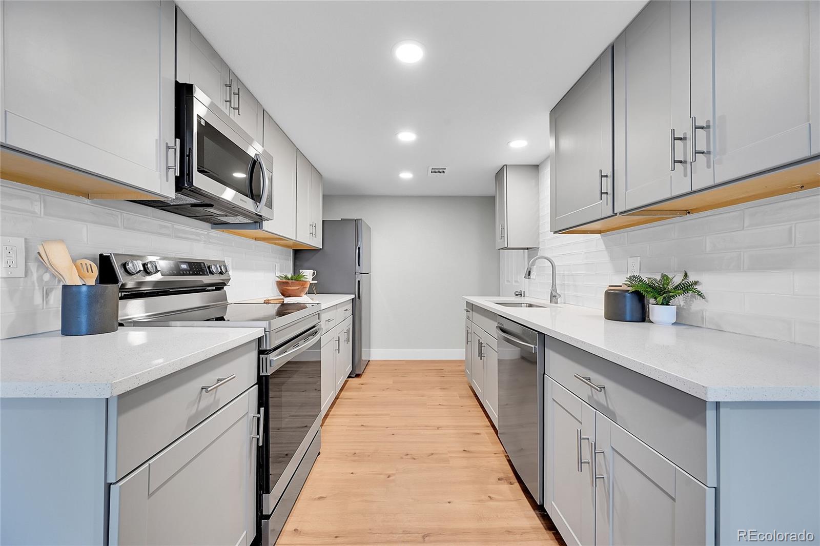 1344 Sable Boulevard Aurora, CO 80011 - Photo 1 of 31 a kitchen with stainless steel appliances granite countertop a sink and dishwasher a stove top oven with wooden floor