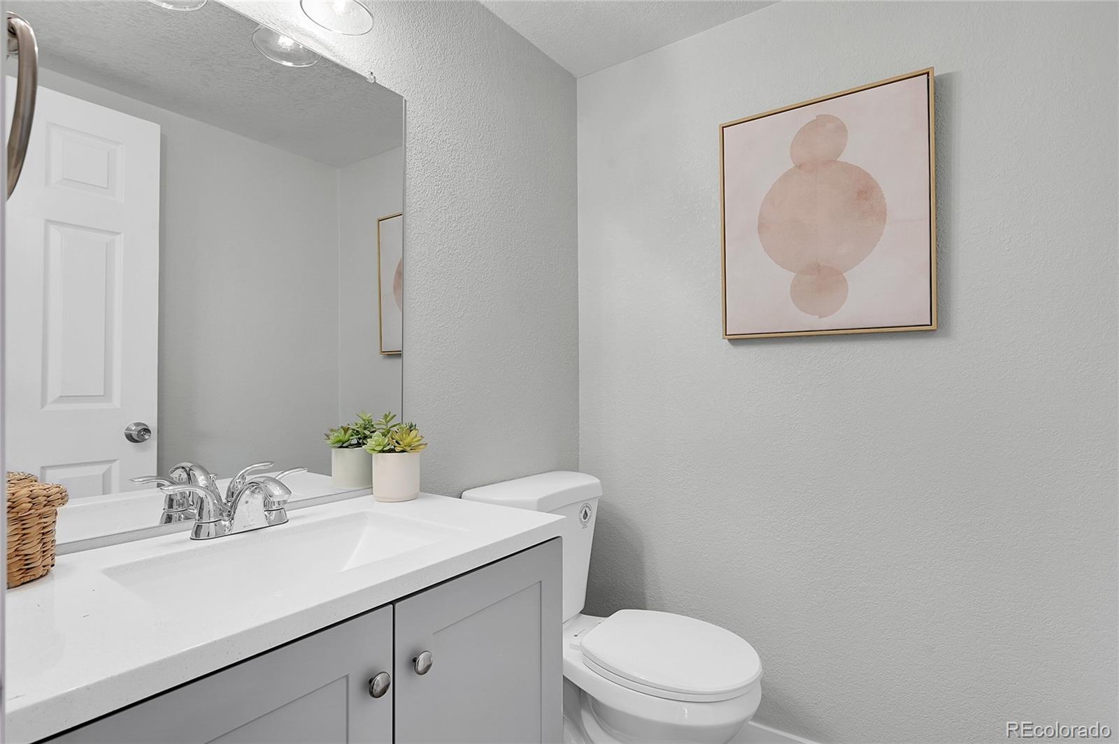 1344 Sable Boulevard Aurora, CO 80011 - Photo 14 of 31 a bathroom with a granite countertop sink mirror vanity and toilet