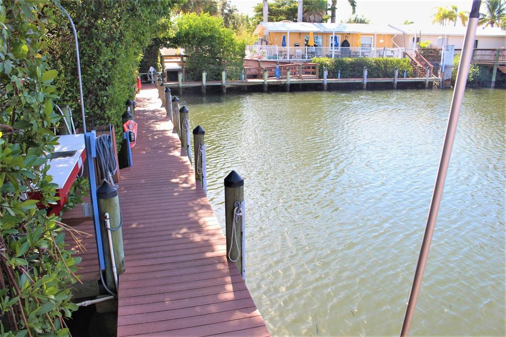570 Blackburn Point Road, Unit LNG42 Osprey, FL 34229 - Photo 8 of 15 a small pool with lawn chairs sitting next to a lake view
