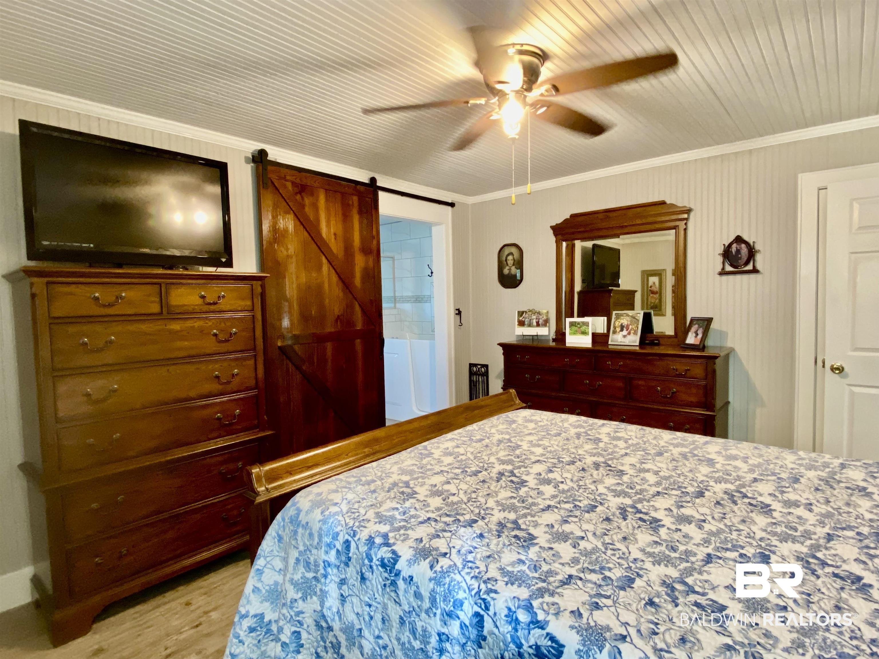 2711 County Road 5 Repton, AL 36475 - Photo 20 of 36 Bedroom featuring ceiling fan, crown molding, and a barn door