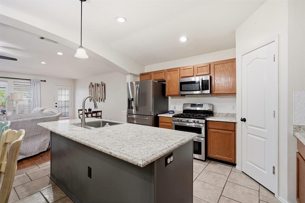 1213 Hampton Drive Forney, TX 75126 - Photo 9 of 27 a kitchen with a sink a microwave a stove and refrigerator