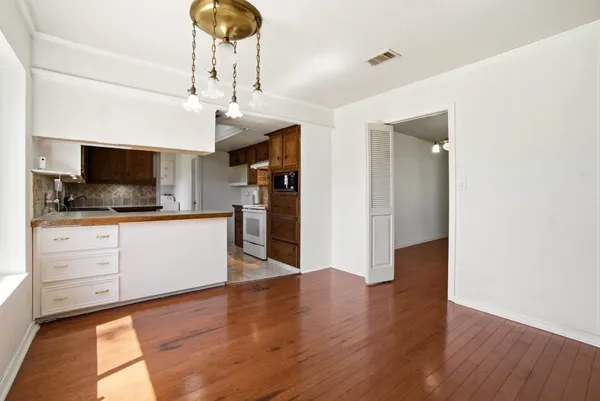a kitchen with granite countertop a sink cabinets stainless steel appliances and wooden floor