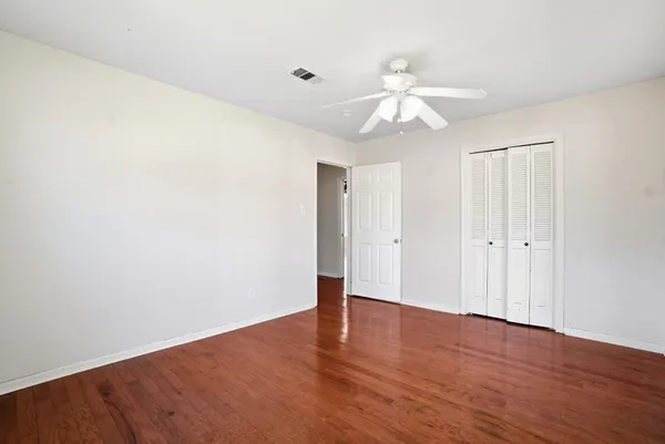 a view of an empty room with wooden floor