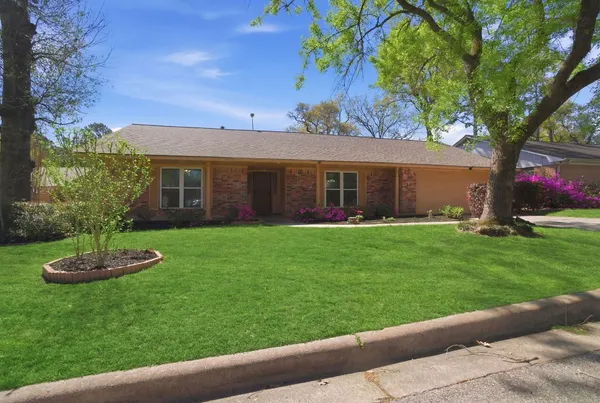 a front view of a house with a garden and yard