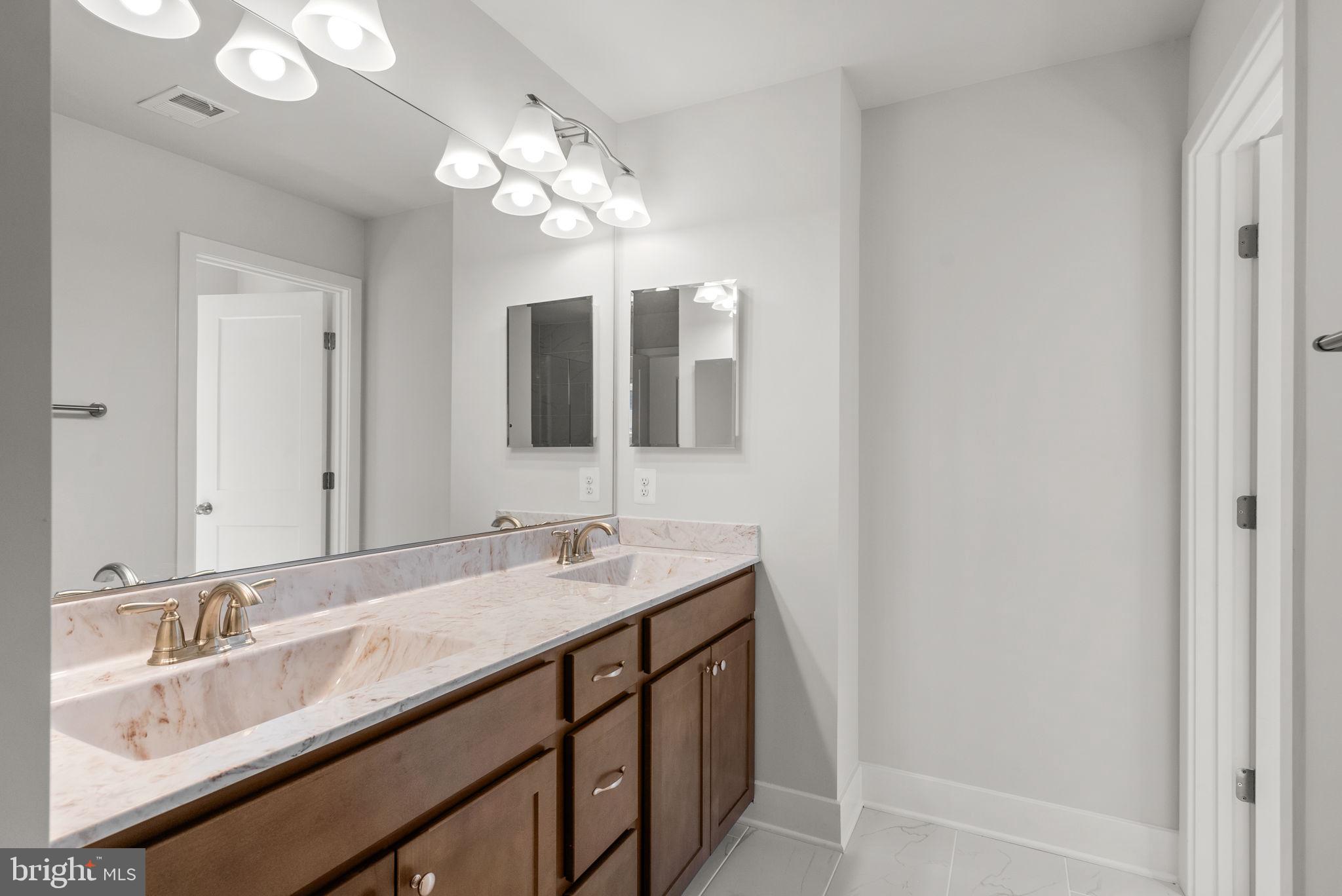 9425 Fairview Avenue Laurel, MD 20723 - Photo 36 of 125 a bathroom with a double vanity sink and a mirror