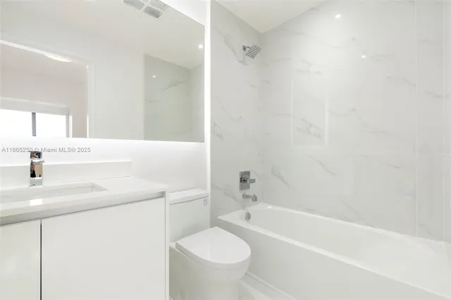 a view of a kitchen with a sink and dishwasher a refrigerator with white cabinets