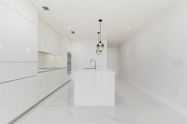 a kitchen with kitchen island a counter top space appliances and cabinets