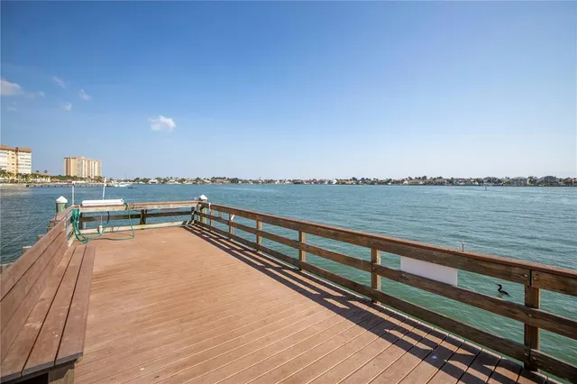 a kitchen with stainless steel appliances granite countertop a stove a sink dishwasher and a refrigerator with wooden floor