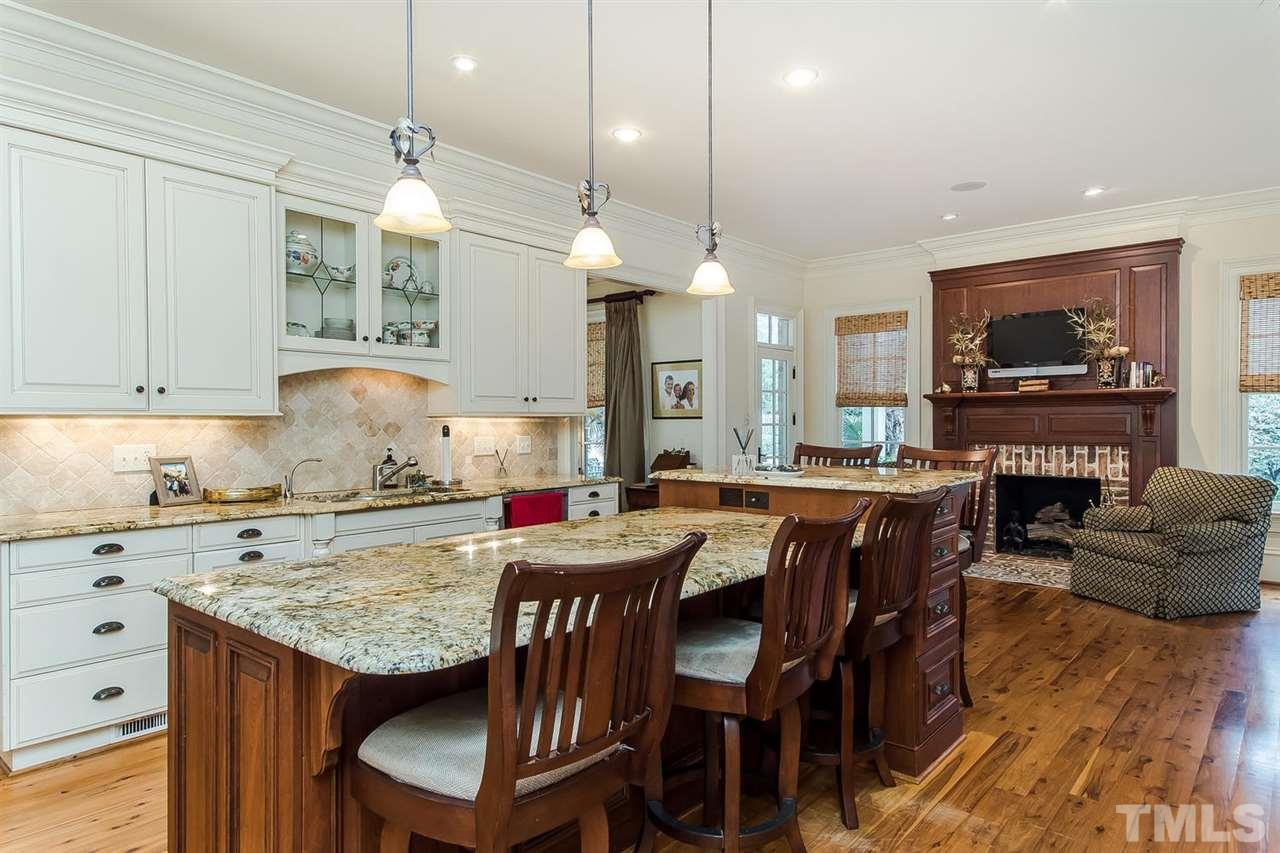 508 Marlowe Road Raleigh, NC 27609 - Photo 16 of 25 a kitchen with granite countertop a table chairs a sink dishwasher stove and cabinets with wooden floor
