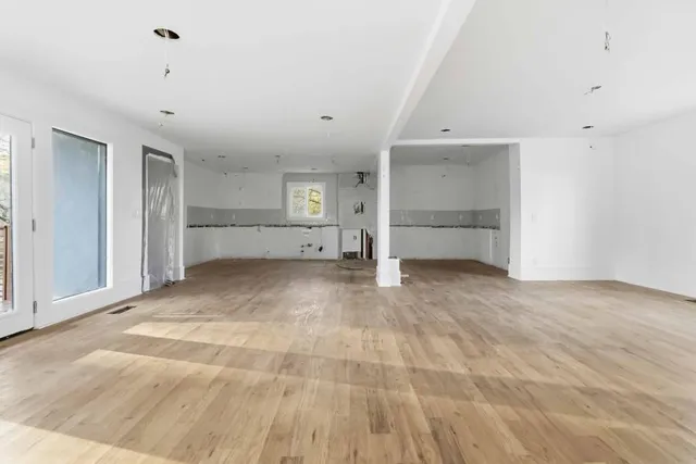 a view of a livingroom with wooden floor and a fireplace