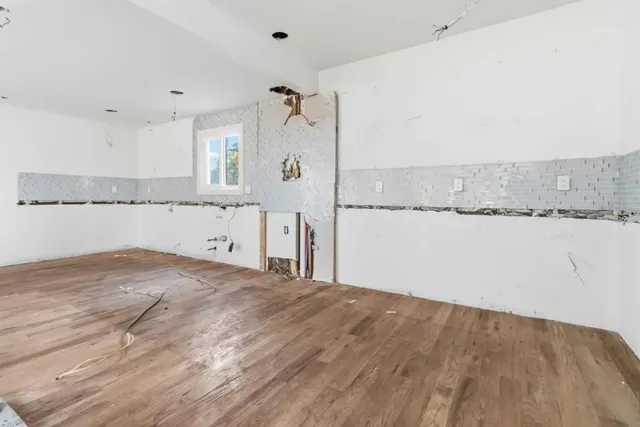 a view of a kitchen with white cabinets and a wooden floor