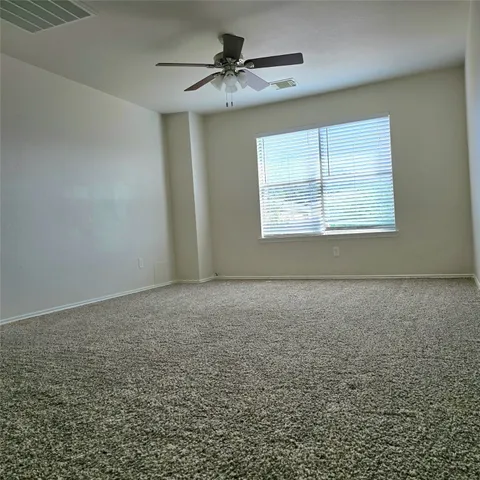 en empty room with windows and fan