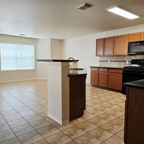 a kitchen with stainless steel appliances granite countertop a stove top oven a sink a counter top space and cabinets