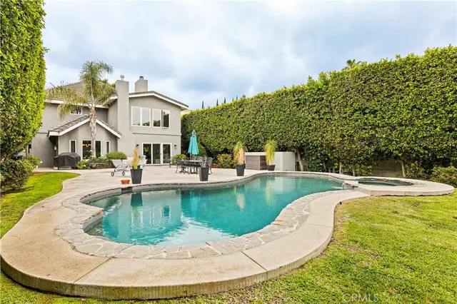a view of a house with swimming pool and sitting area