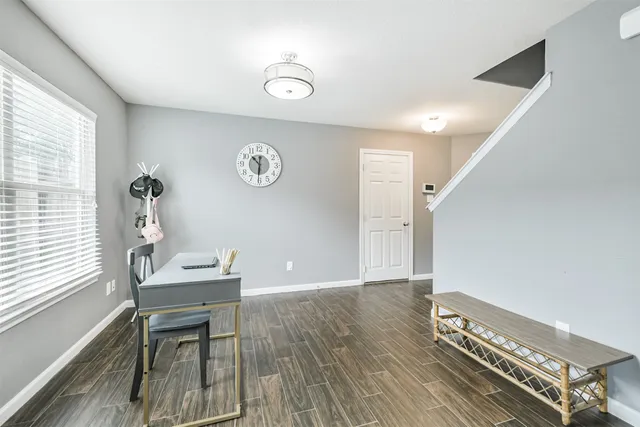 a view of a workspace with furniture and a window