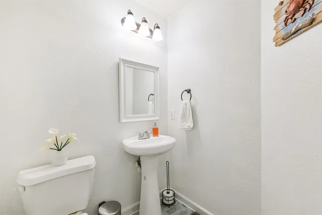 a bathroom with a sink toilet and a mirror