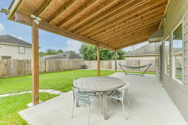 a view of a patio with a table chairs and a backyard