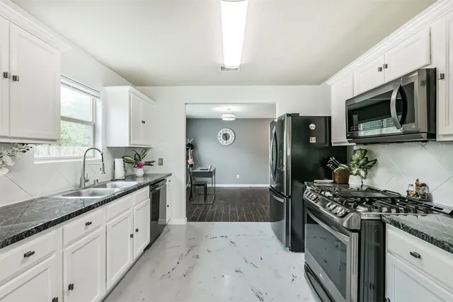 a kitchen with stainless steel appliances granite countertop a sink stove and refrigerator