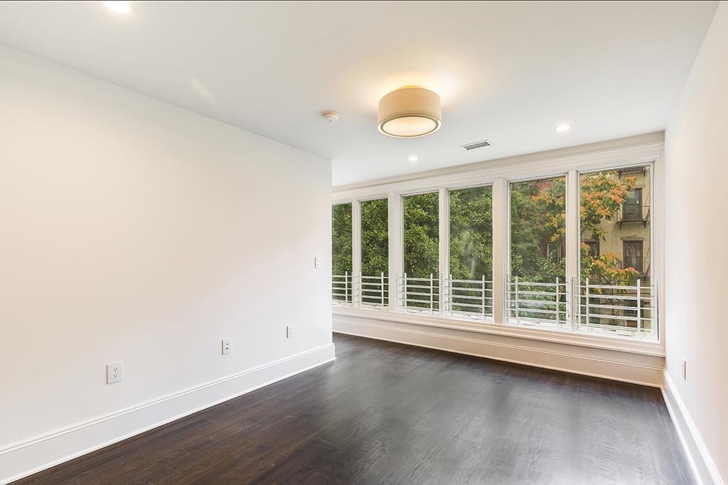 206 8th Street Hoboken, NJ 07030 - Photo 28 of 35 an empty room with wooden floor and windows