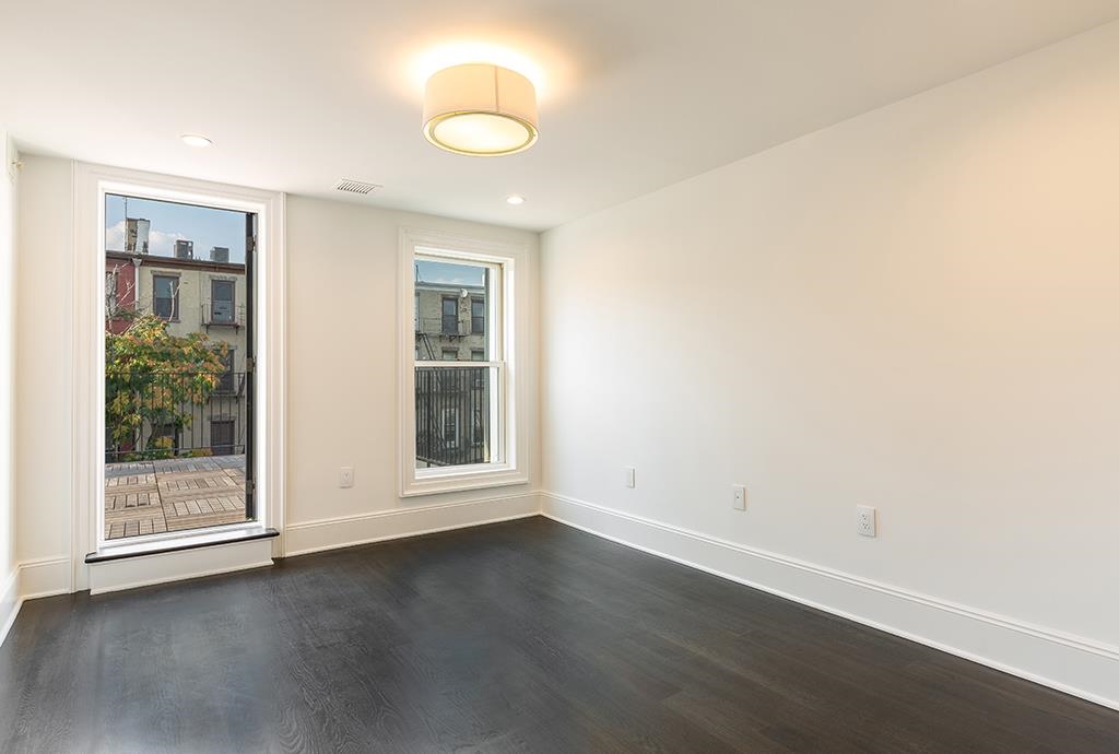 206 8th Street Hoboken, NJ 07030 - Photo 29 of 35 an empty room with wooden floor and windows