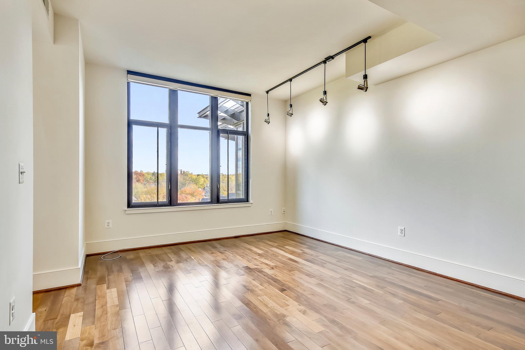 4301 Military Road Northwest, Unit PH5 Washington, DC 20015 - Photo 15 of 53 a view of an empty room with wooden floor and a window