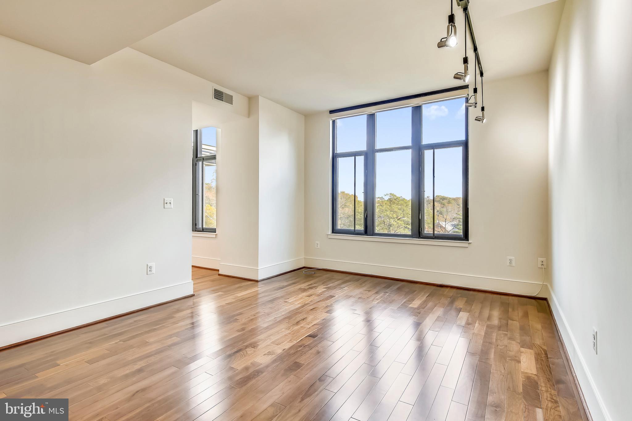 4301 Military Road Northwest, Unit PH5 Washington, DC 20015 - Photo 16 of 53 a view of an empty room with glass window and hardwood floor