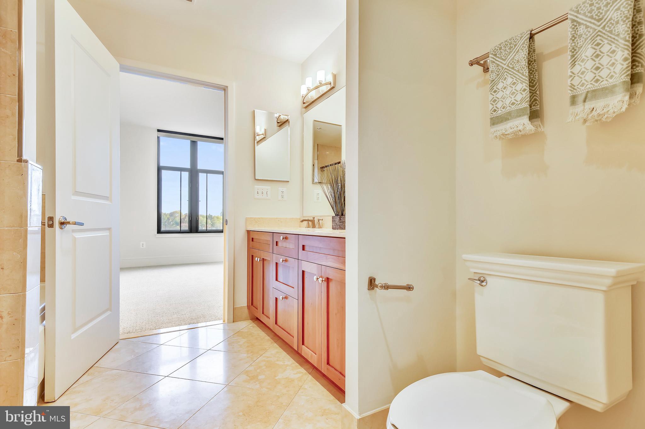 4301 Military Road Northwest, Unit PH5 Washington, DC 20015 - Photo 25 of 53 a bathroom with a granite countertop toilet sink and shower