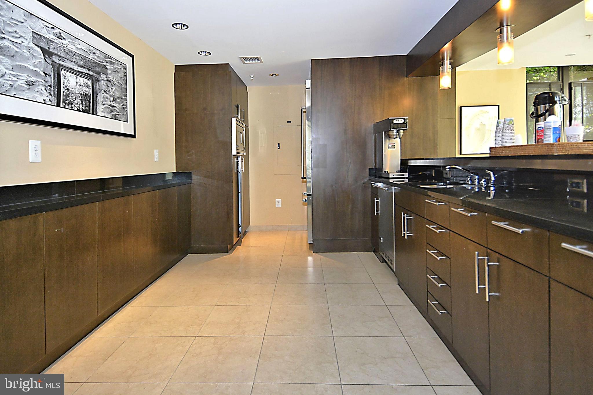 4301 Military Road Northwest, Unit PH5 Washington, DC 20015 - Photo 40 of 53 a kitchen with stainless steel appliances granite countertop a refrigerator and a stove top oven