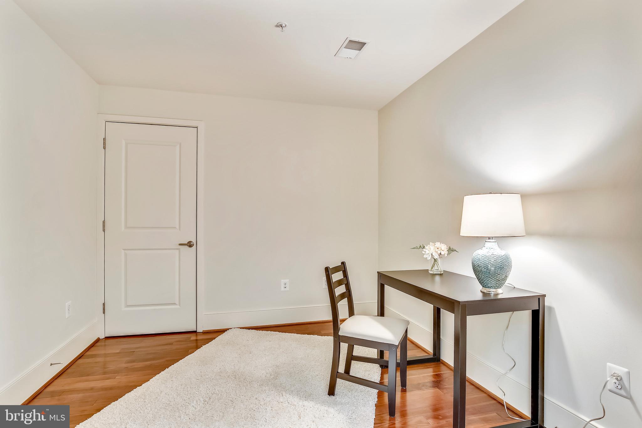 4301 Military Road Northwest, Unit PH5 Washington, DC 20015 - Photo 6 of 53 a bedroom with a bed and a lamp on table