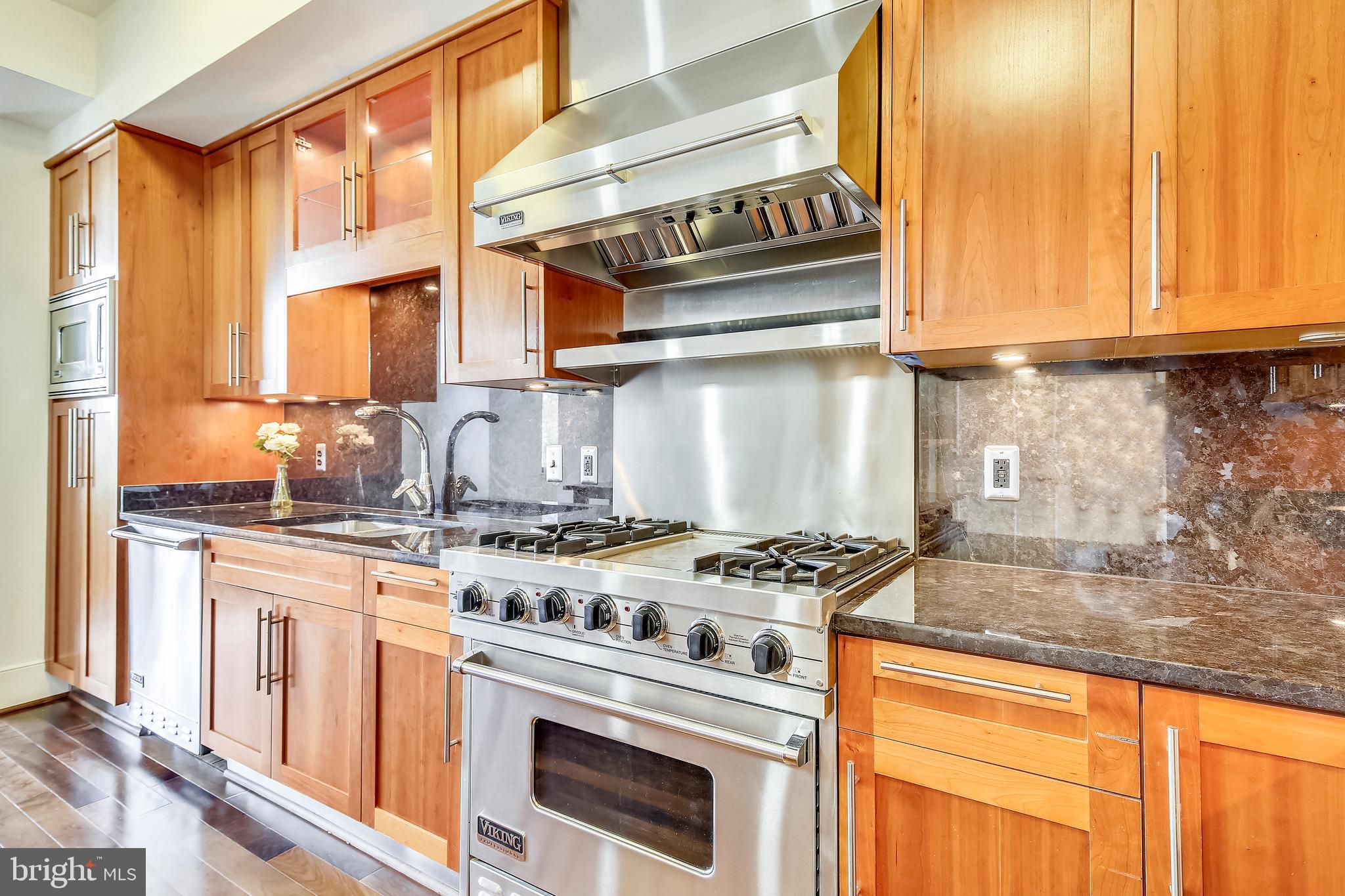 4301 Military Road Northwest, Unit PH5 Washington, DC 20015 - Photo 9 of 53 a kitchen with stainless steel appliances granite countertop a stove a sink and a microwave