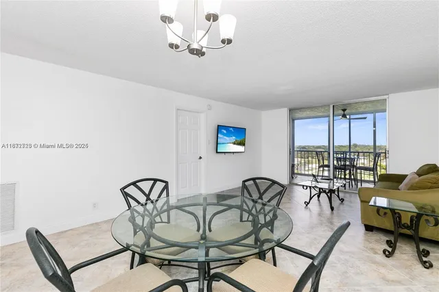a view of a livingroom and a dining room with furniture window and outside view