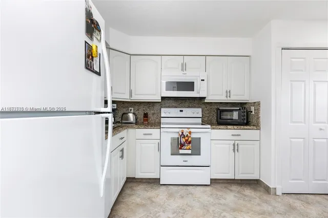 a kitchen with stainless steel appliances a refrigerator sink and white cabinets