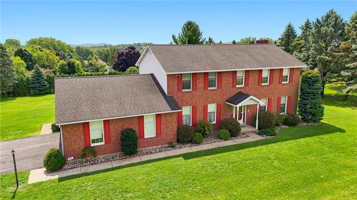 6090 Stone Post Road Bath, PA 18014 - Photo 3 of 57 A well-kept lawn encircles this brick-faced home, featuring a prominent front entrance and neatly manicured landscaping.