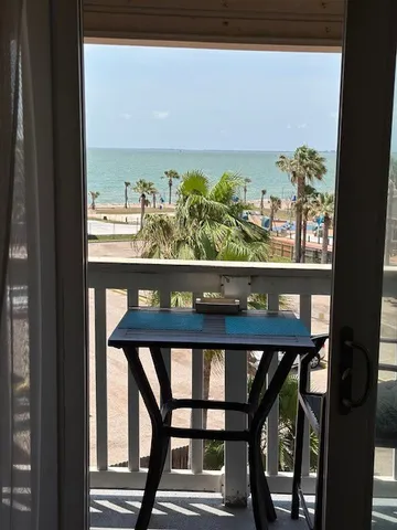 a view of a balcony with chairs and wooden floor