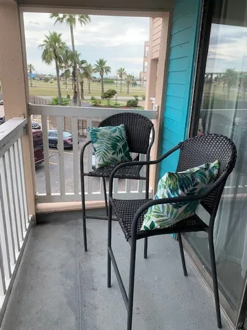 a balcony view with couple of chairs and a potted plant