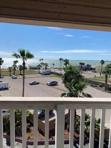 a view of a balcony with chairs and a potted plant