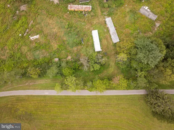 a white house with a big yard and large trees
