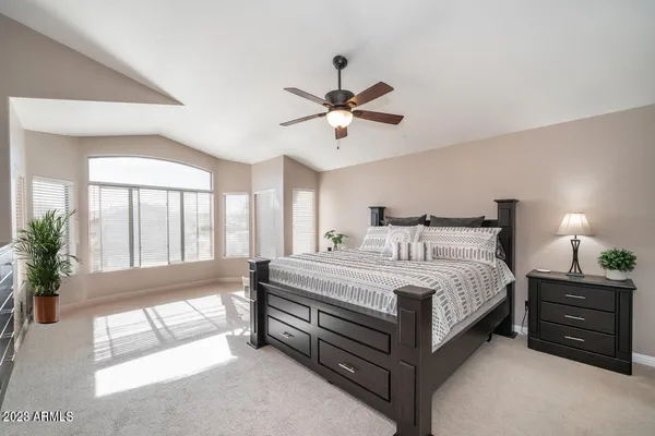 a spacious bedroom with a bed and a large window
