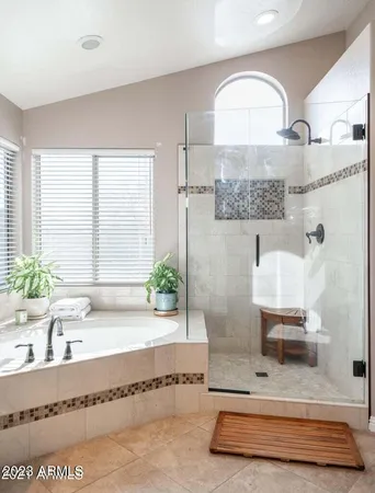 a bathroom with a tub a double vanity sink and a large mirror