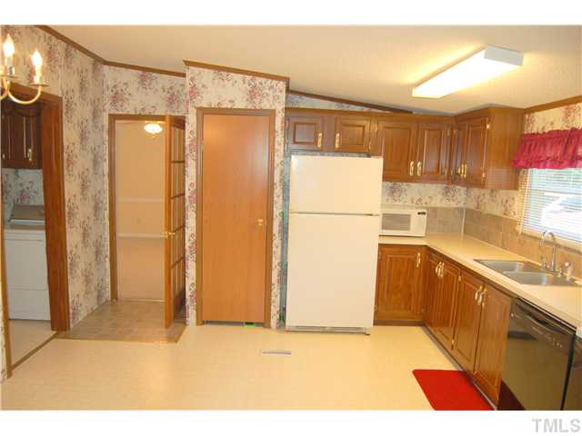 514 Dick Holeman Road Timberlake, NC 27583 - Photo 4 of 21 a kitchen with a refrigerator a sink and cabinets