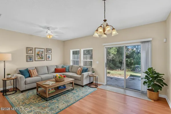 a living room with furniture a chandelier and a window