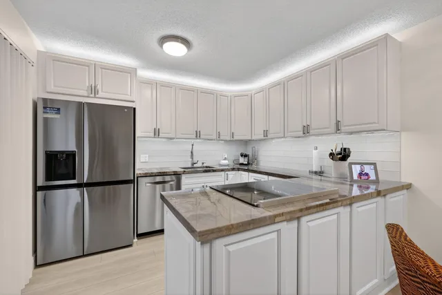 a kitchen with a refrigerator sink and cabinets