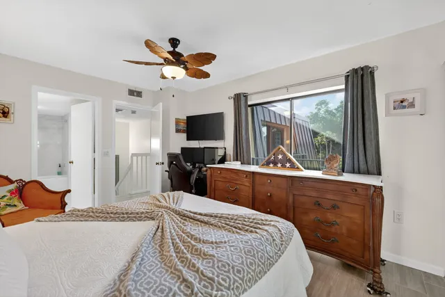 a bedroom with a bed a window and television