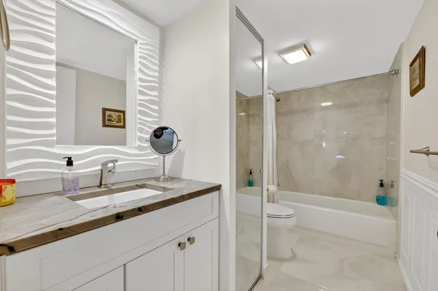 a bathroom with a granite countertop sink mirror and shower