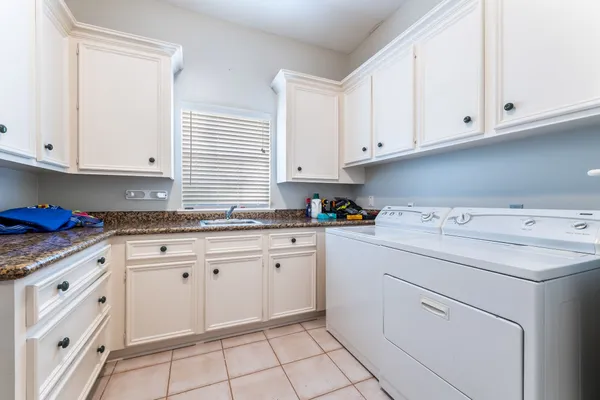 a kitchen with granite countertop white cabinets and white appliances