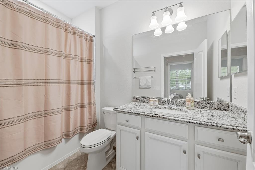 4374 Bismark Way Naples, FL 34119 - Photo 24 of 49 Bathroom featuring a white vanity with shaker-style cabinetry, a granite-finish countertop, and an undermount sink