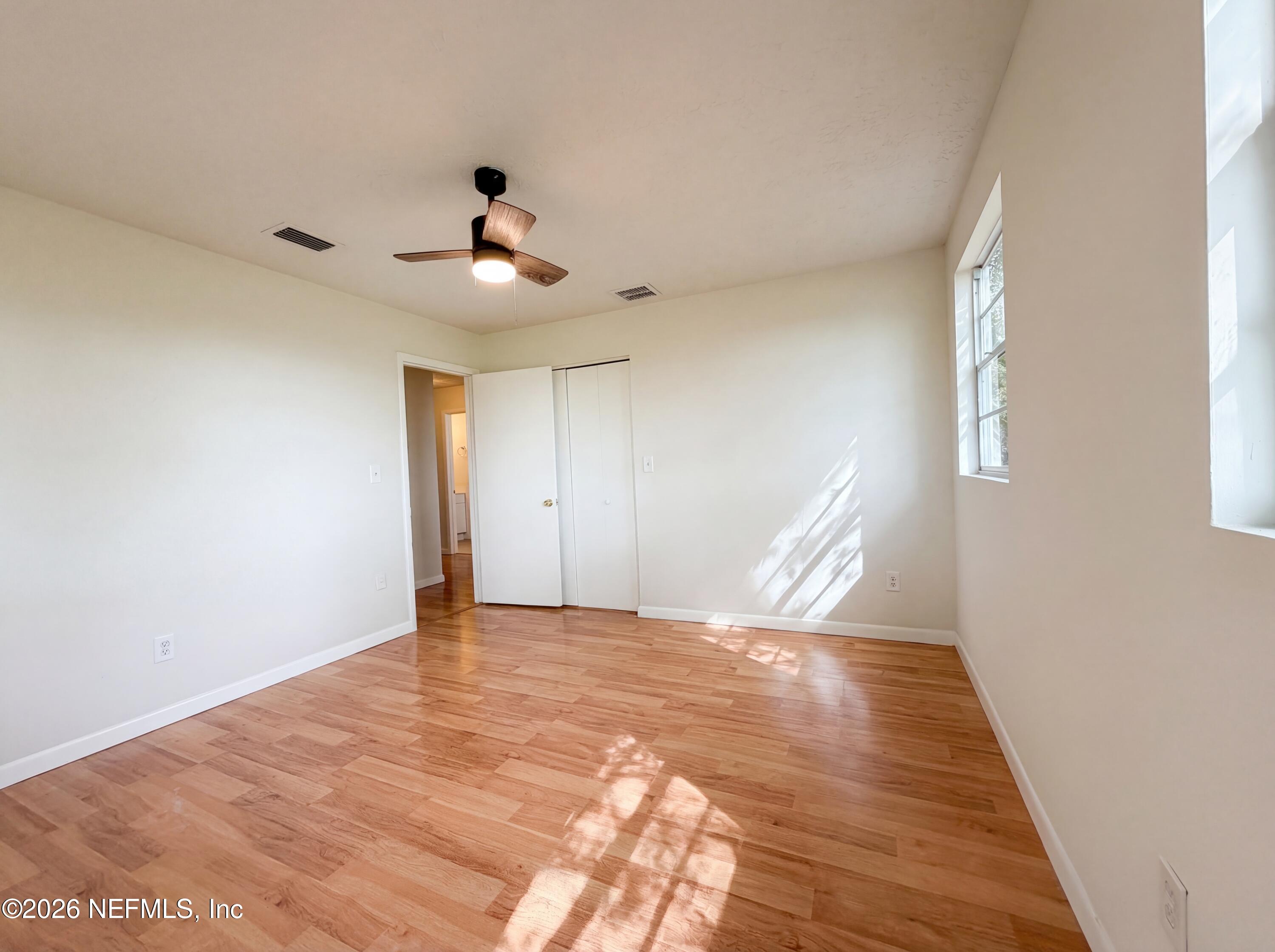 6917 Gatorbone Road Keystone Heights, FL 32656 - Photo 14 of 24 a view of an empty room with wooden floor and a ceiling fan